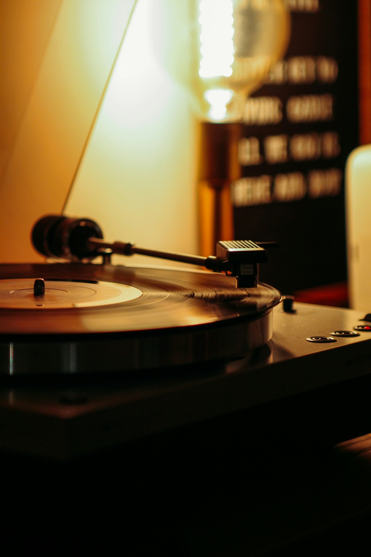 Turntable with vinyl spinning, warm lamp light in background